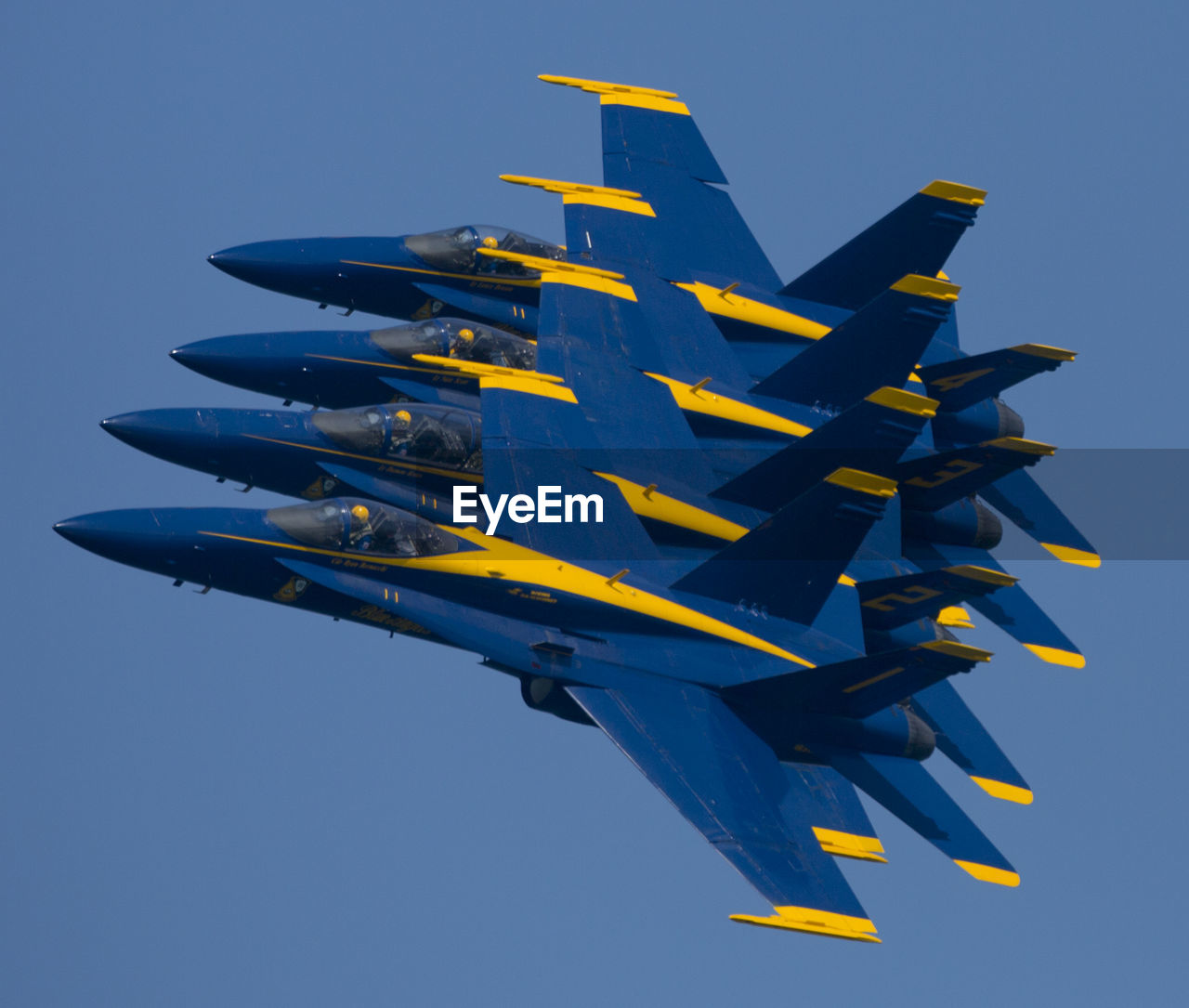 LOW ANGLE VIEW OF AIRPLANE AGAINST BLUE SKY