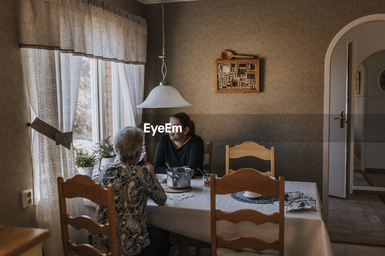 Grandmother and adult granddaughter eating at home