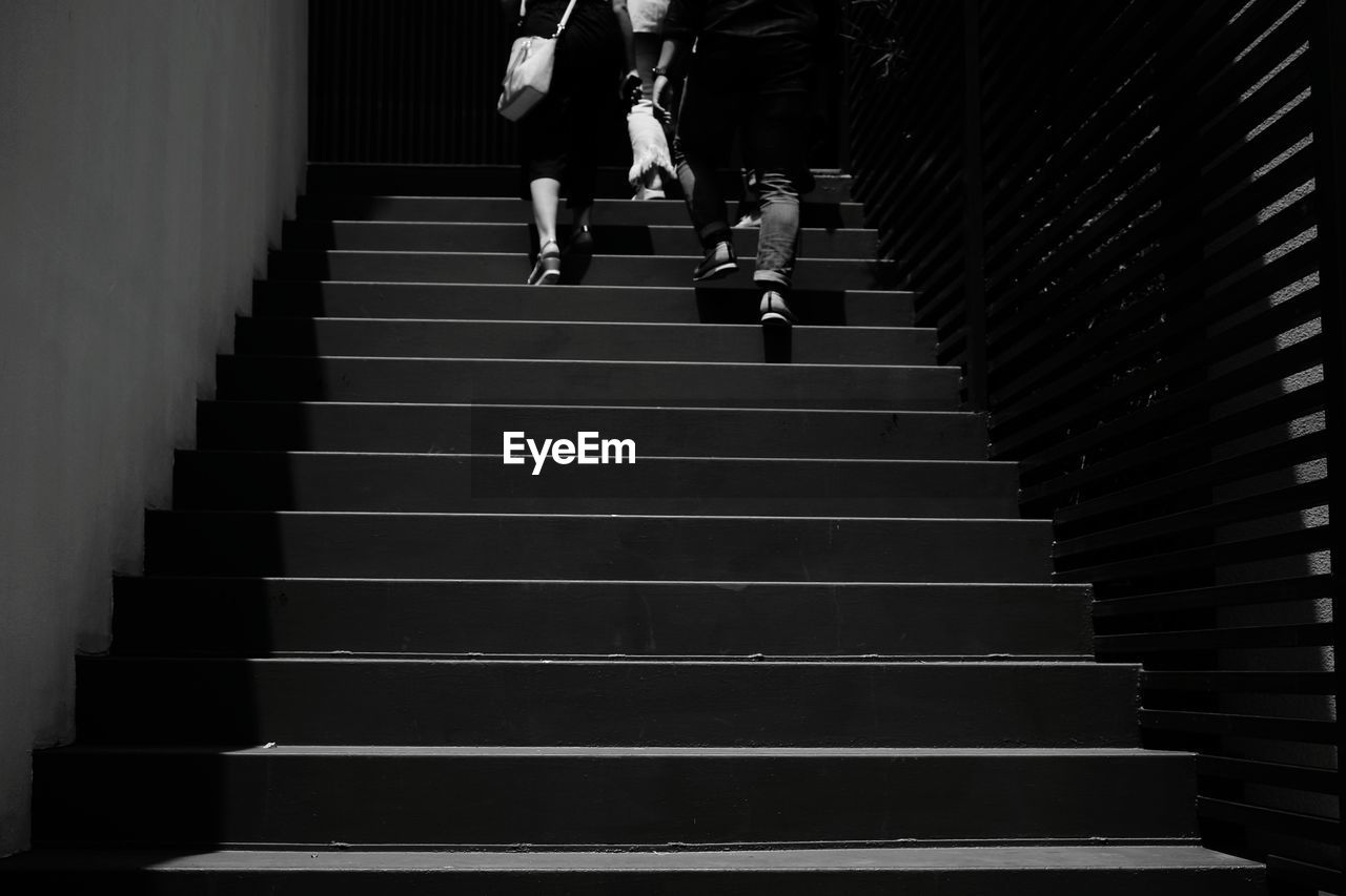 LOW ANGLE VIEW OF PEOPLE WALKING ON STAIRS