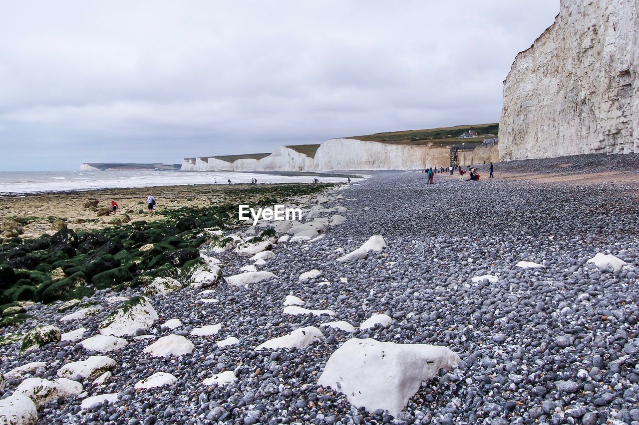 Scenic view of beach against cloudy sky