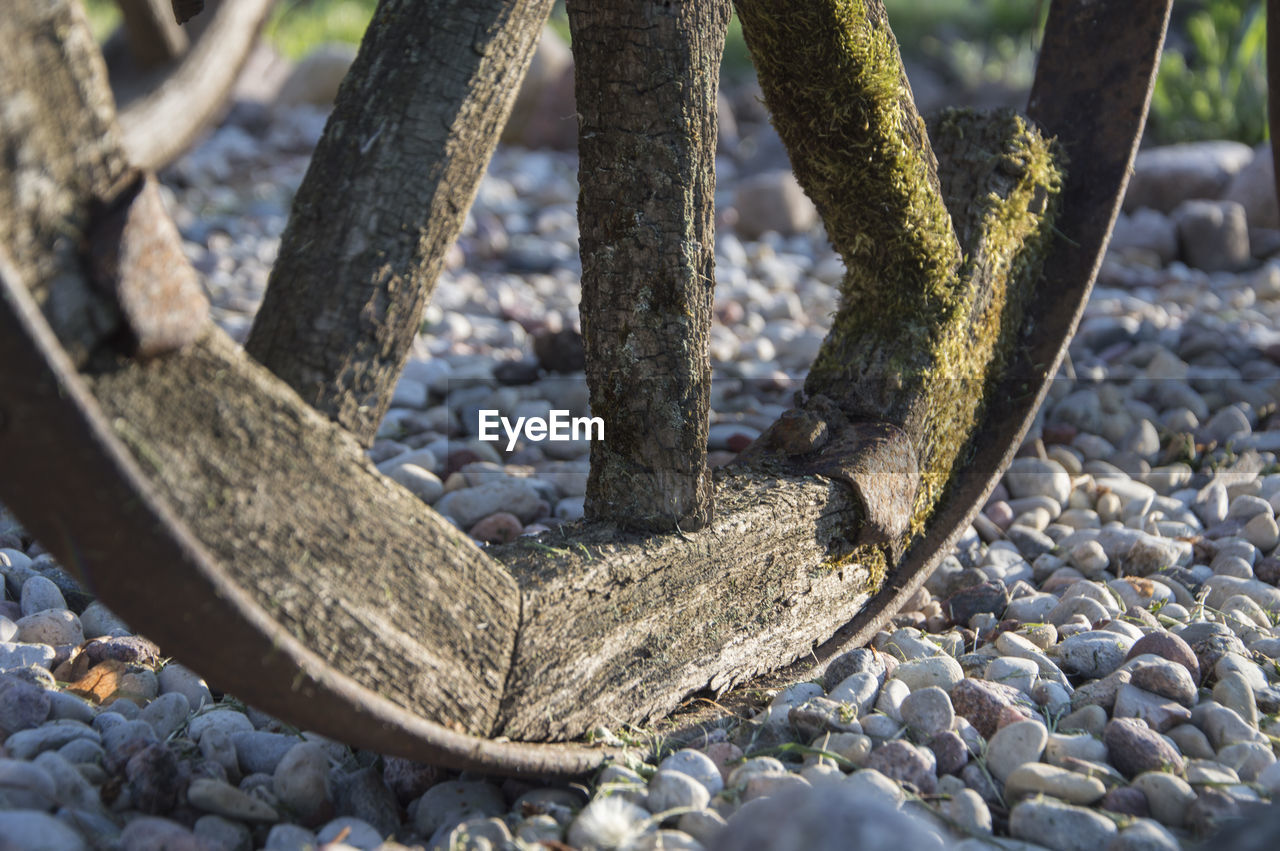 Cropped image of abandoned wheel on stones