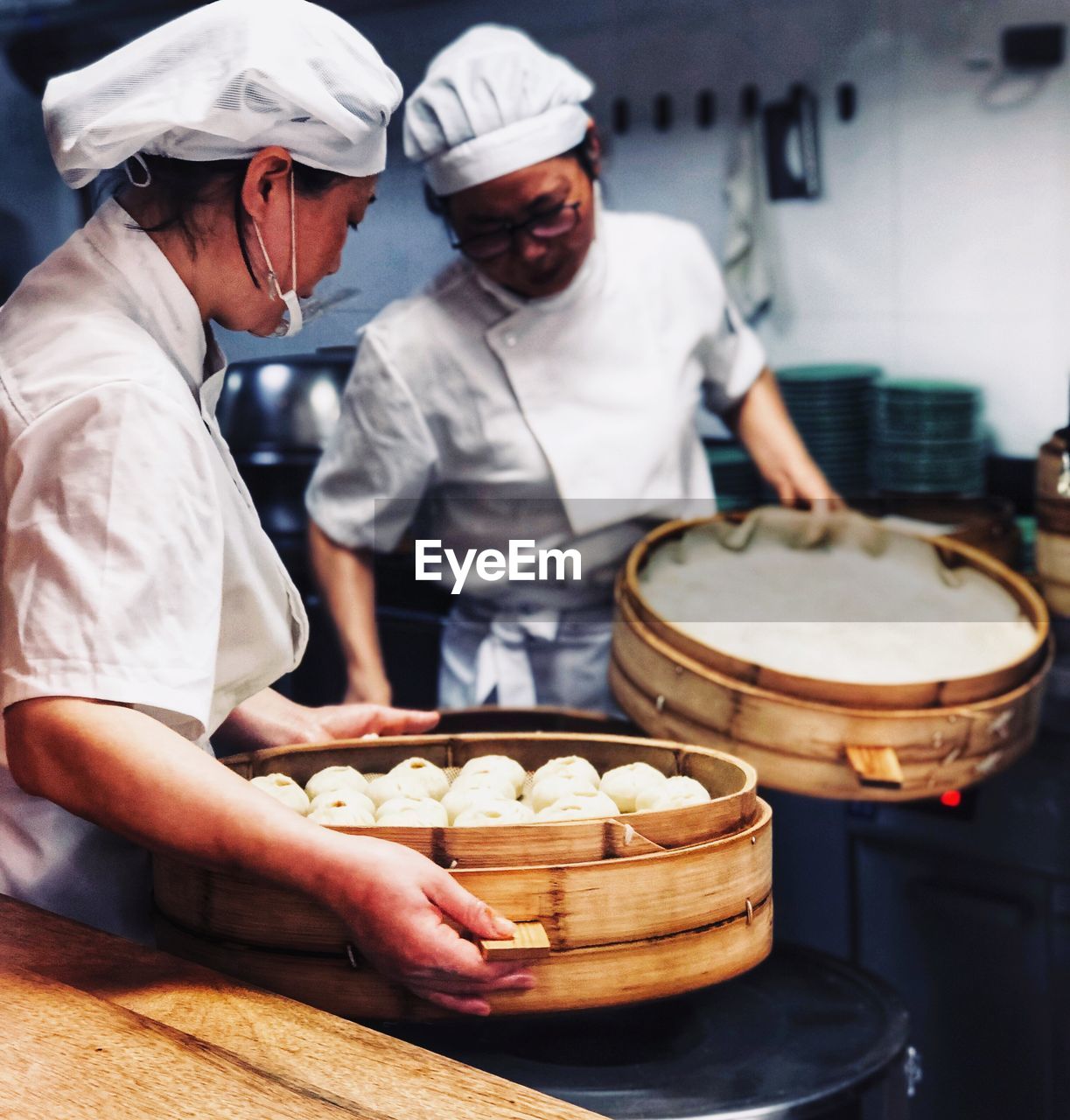 Chefs preparing dumplings in kitchen