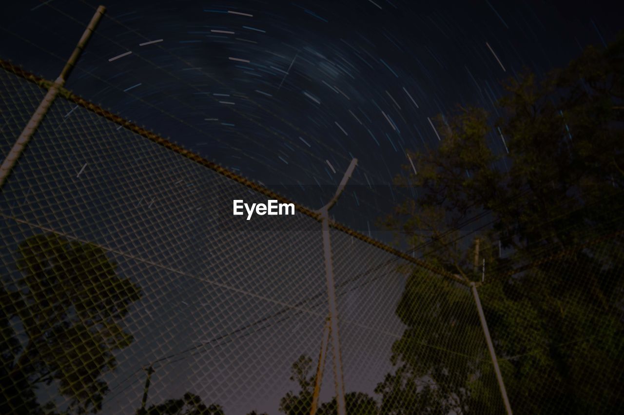 LOW ANGLE VIEW OF ILLUMINATED STAR FIELD AGAINST SKY AT NIGHT