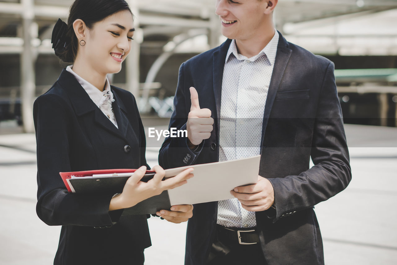 Business people discussing while standing against building