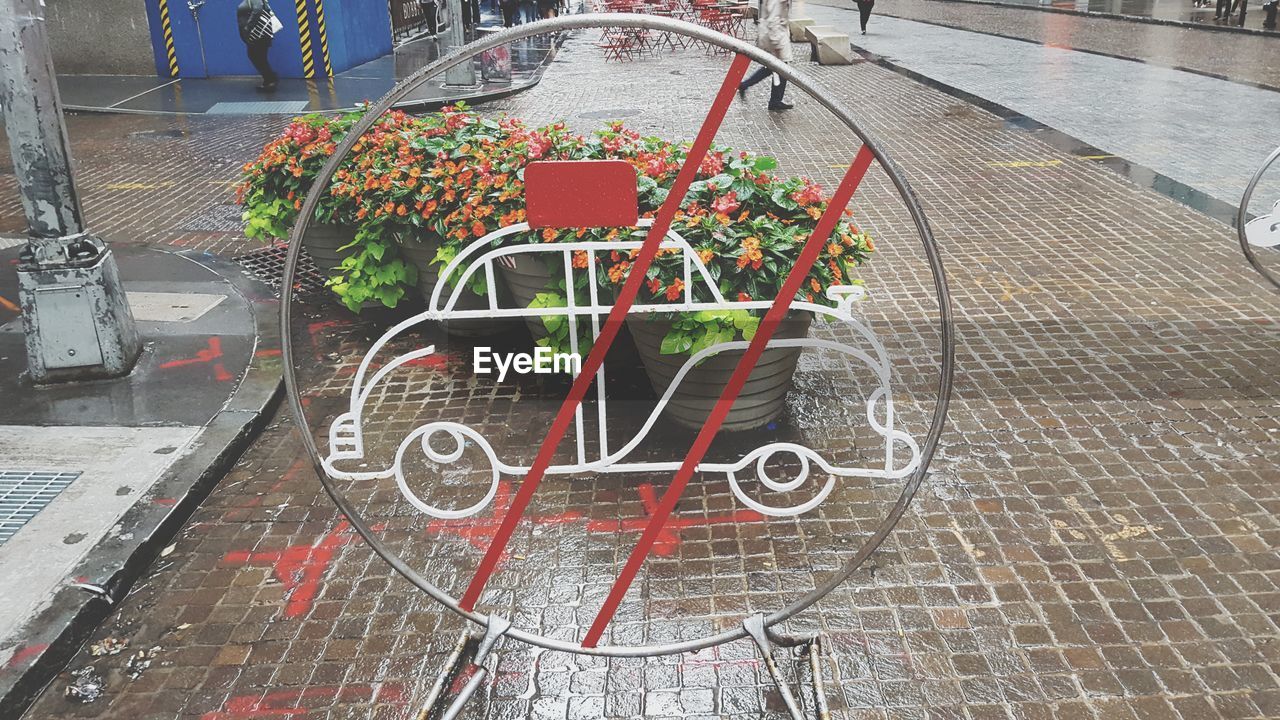 No parking sign against potted plants on footpath