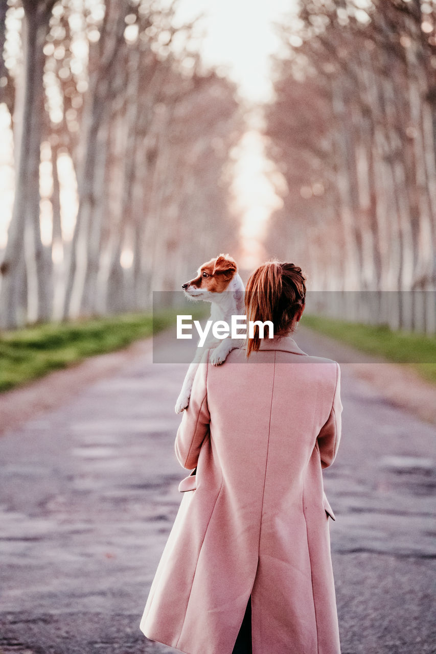 Rear view of woman standing on footpath