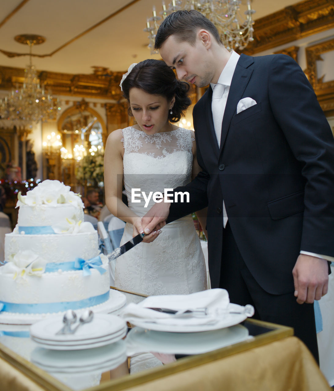 Bride with bridegroom cutting wedding cake