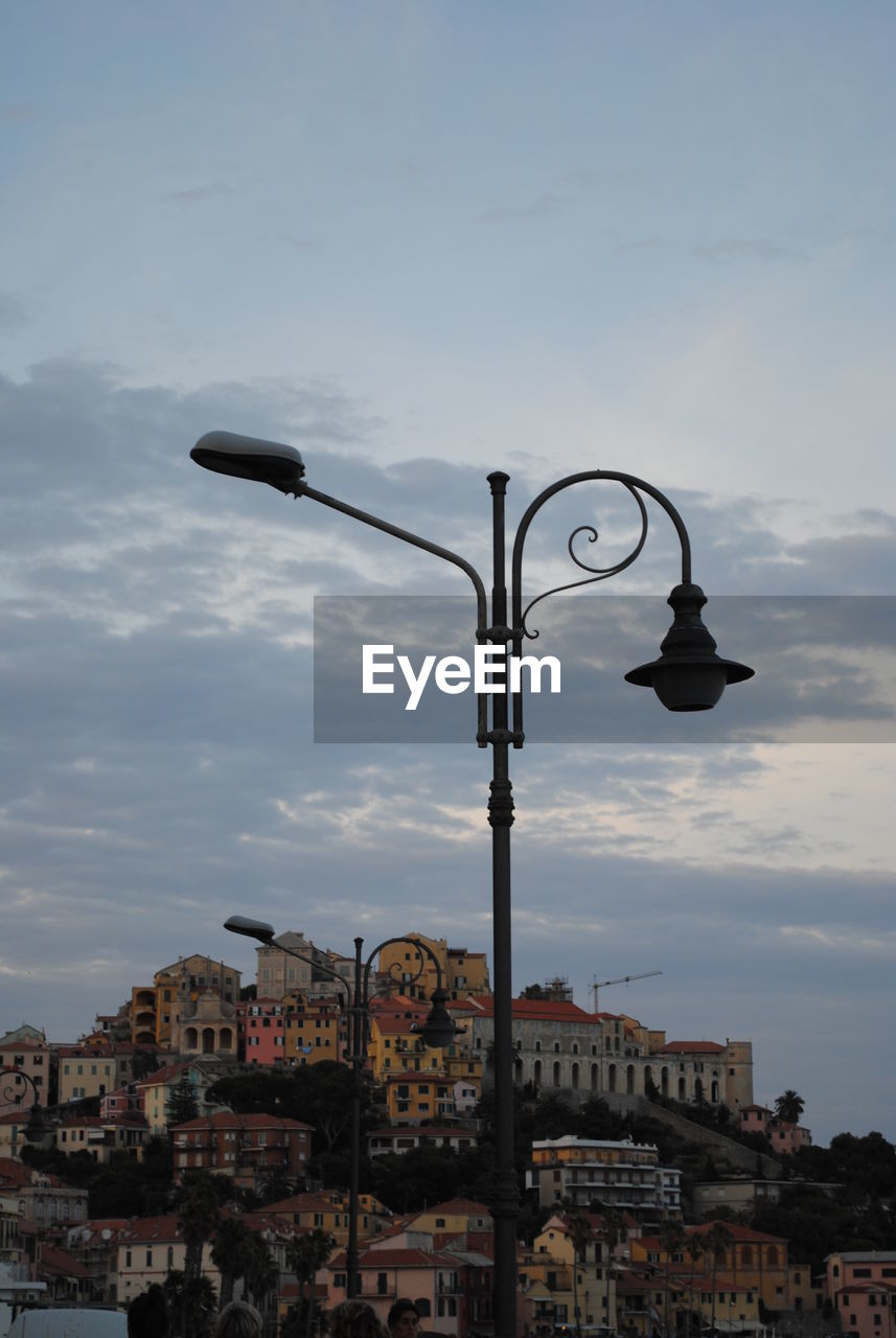 Buildings in city against cloudy sky