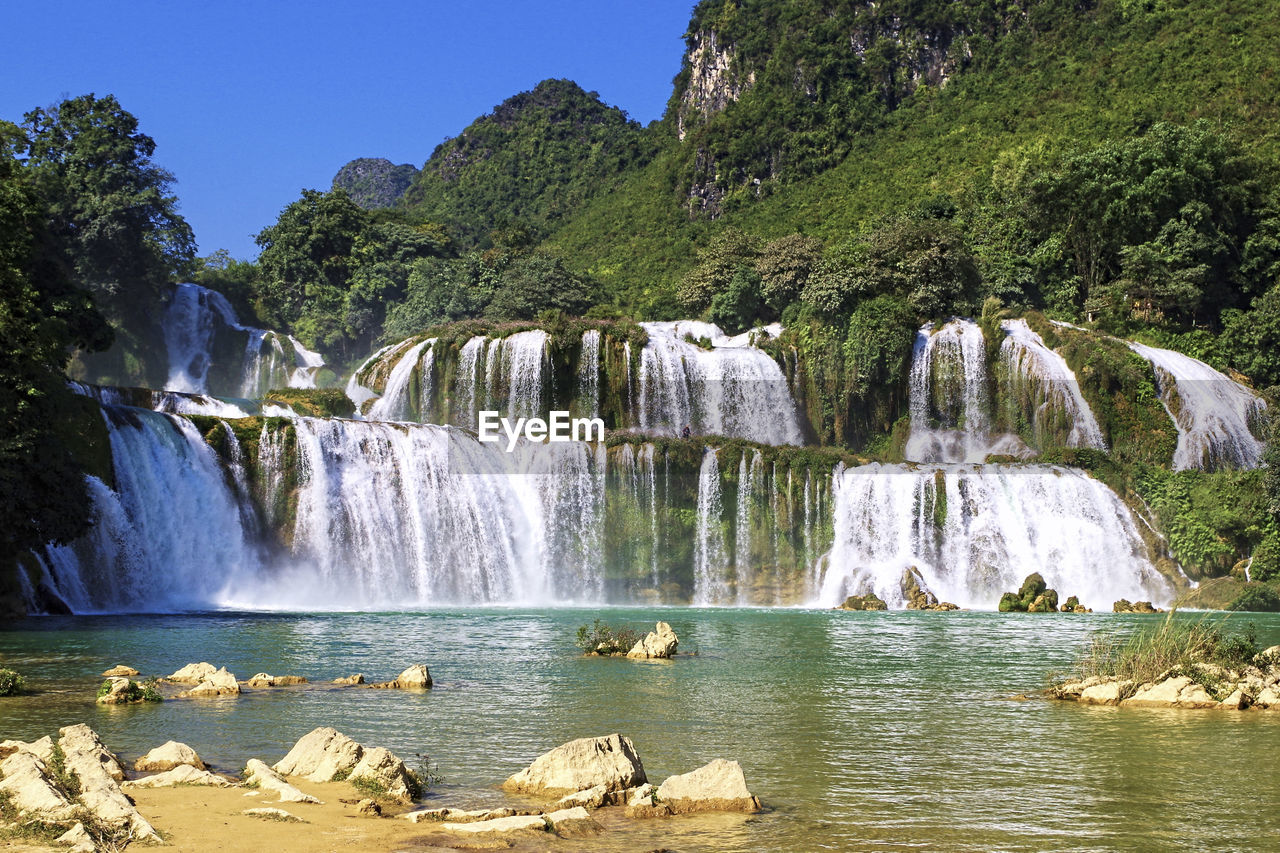 Scenic view of waterfall against sky
