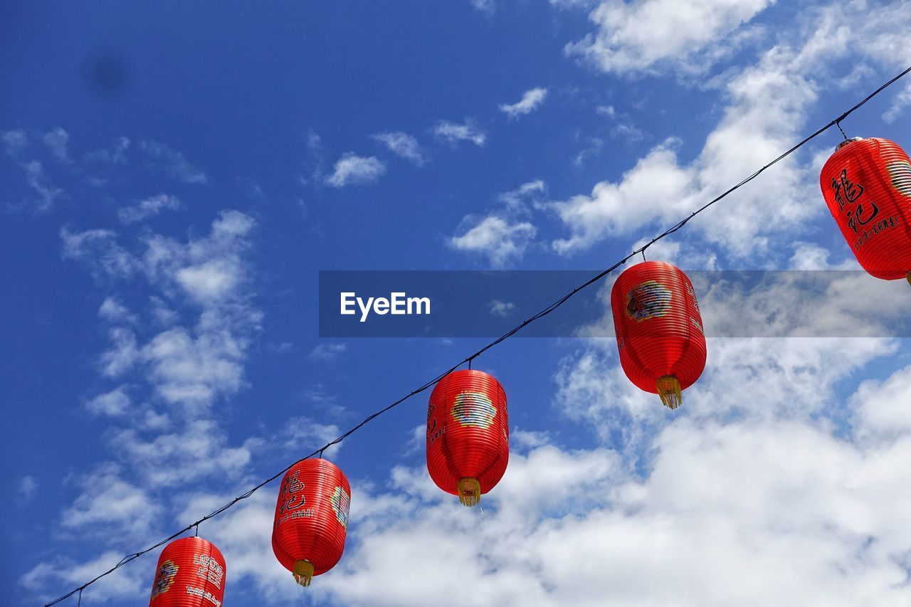 Low angle view of lanterns hanging against sky