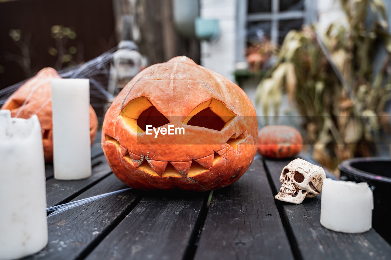 CLOSE-UP OF PUMPKIN ON TABLE AT HOME DURING HALLOWEEN