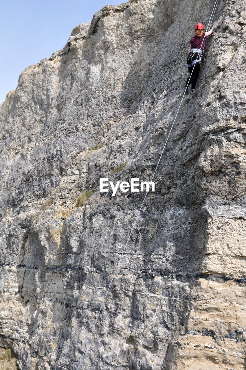 Low angle view of man rock climbing