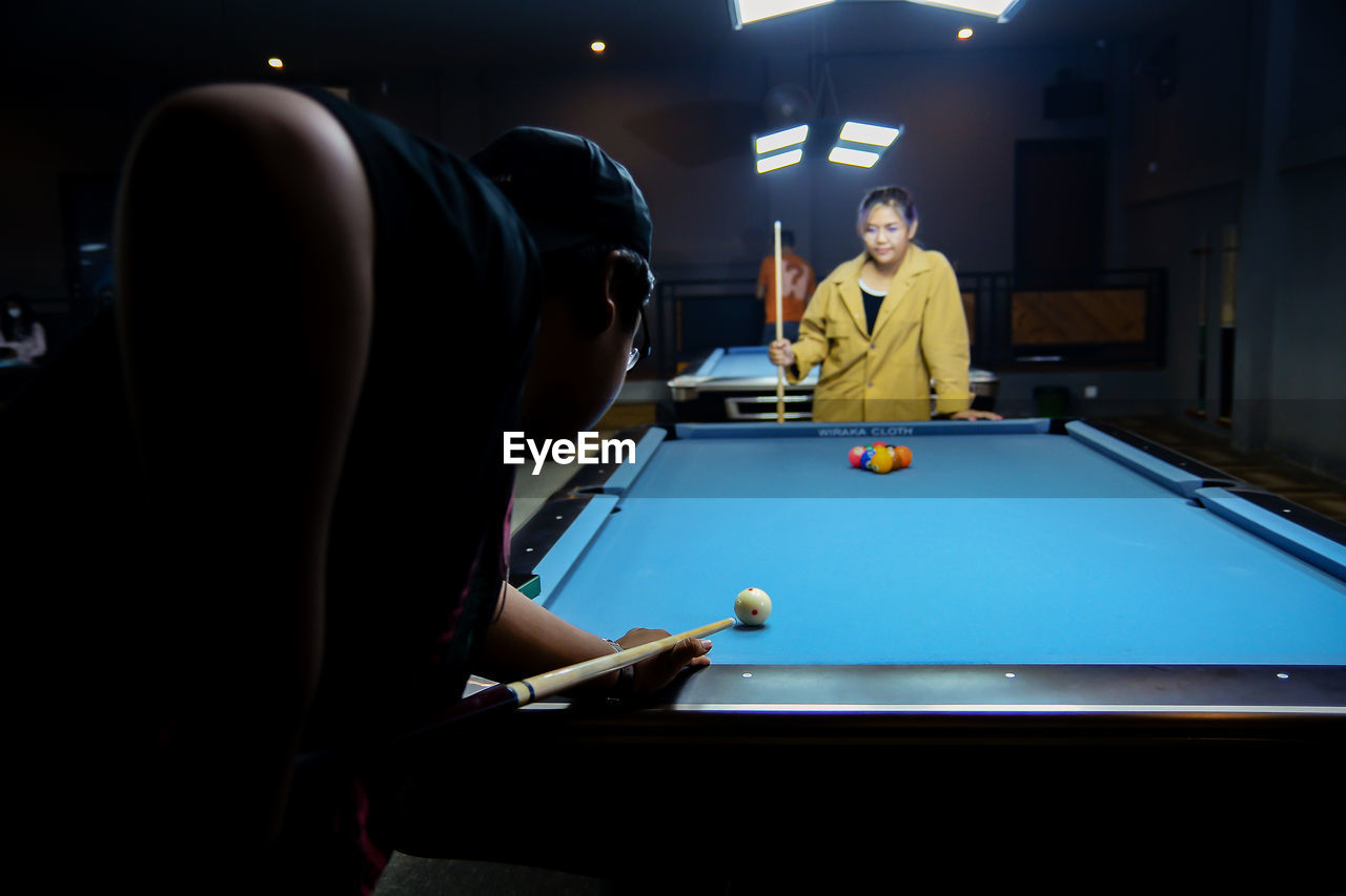 midsection of man playing pool at home