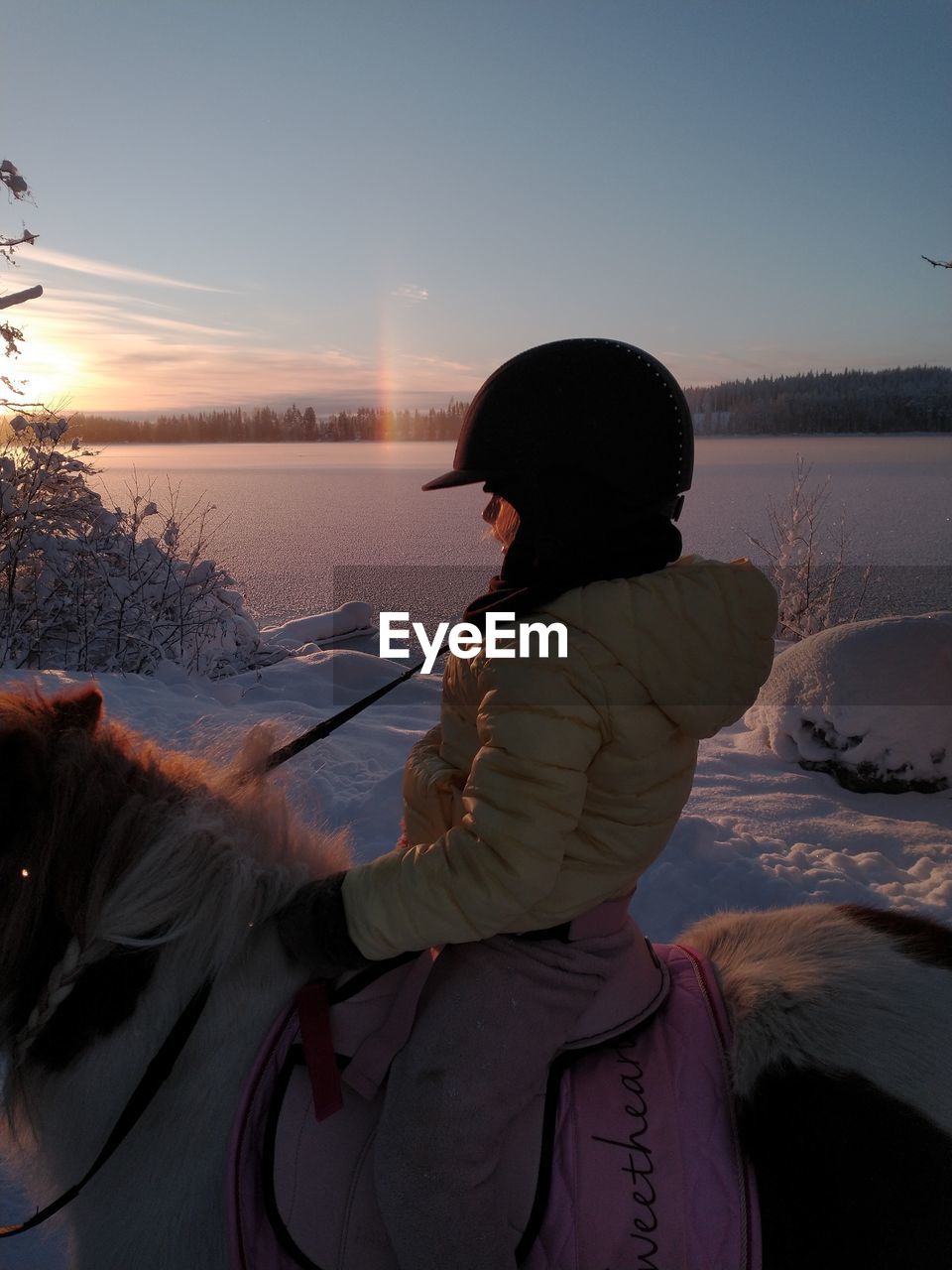 Woman on shore against sky during winter