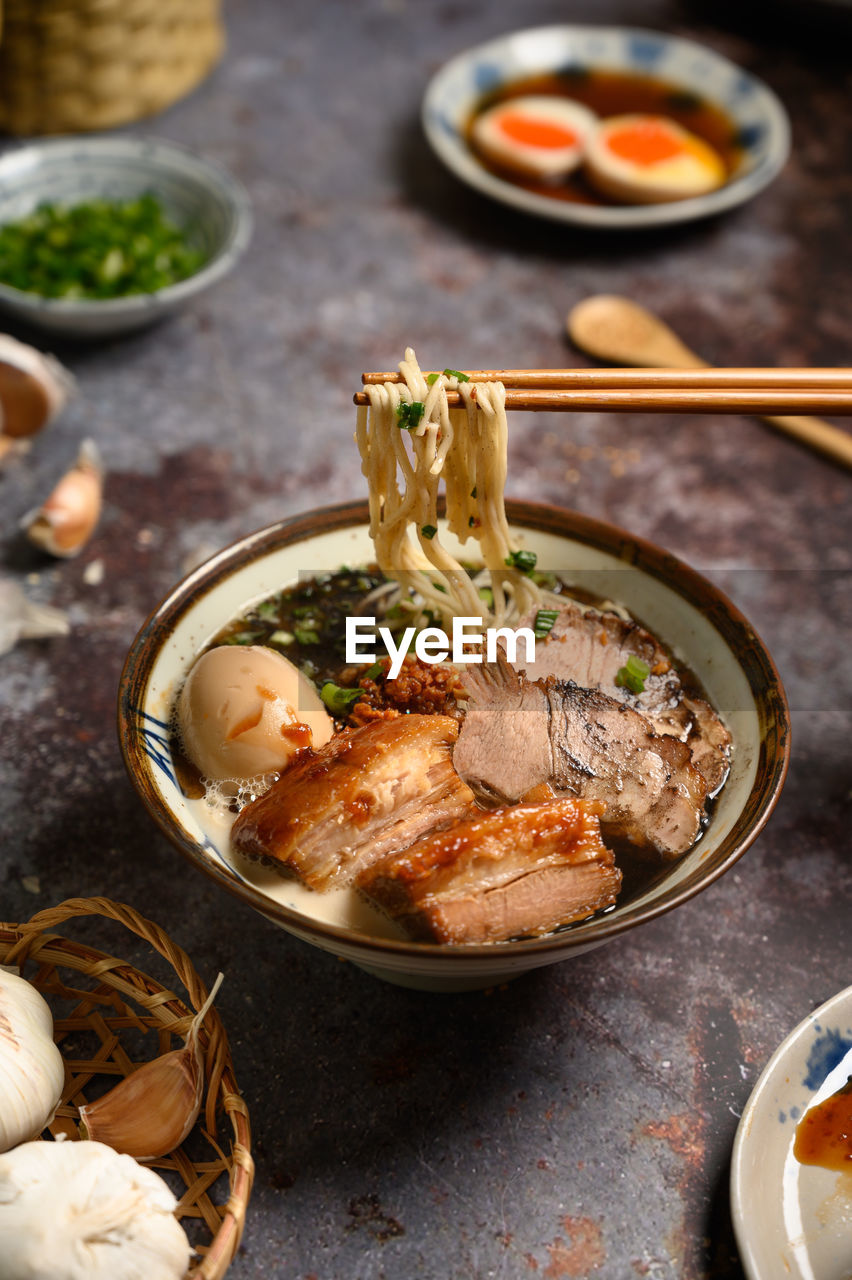 High angle view of food in plate on table. chopsticks with noodles