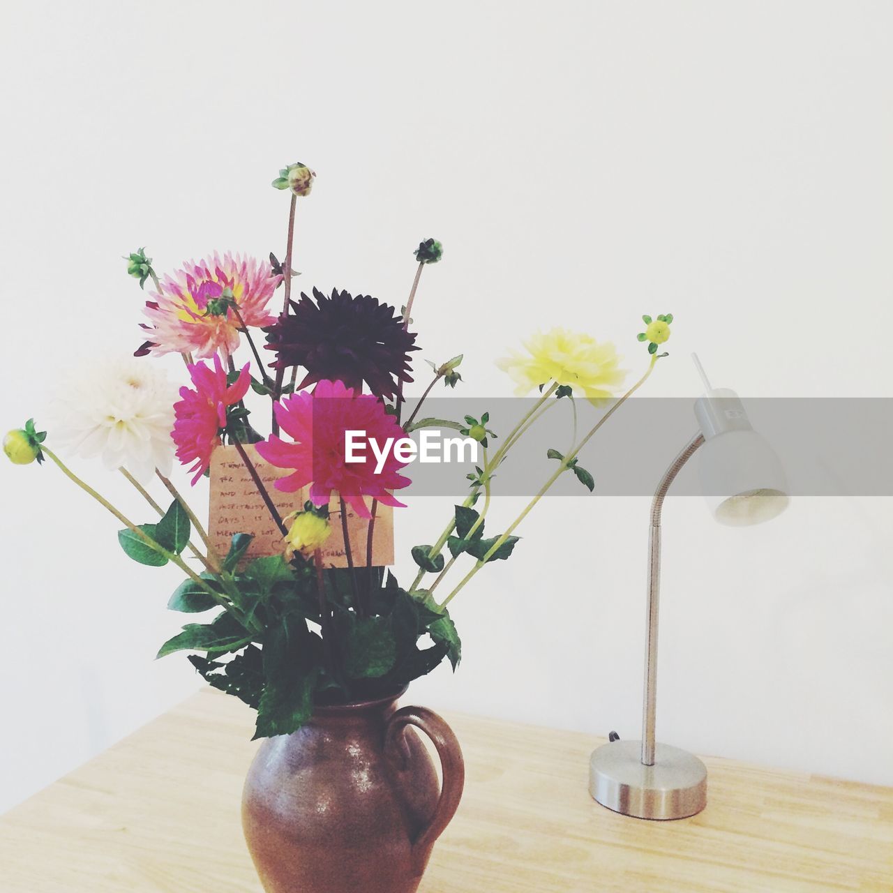 Flowers with message in vase on table