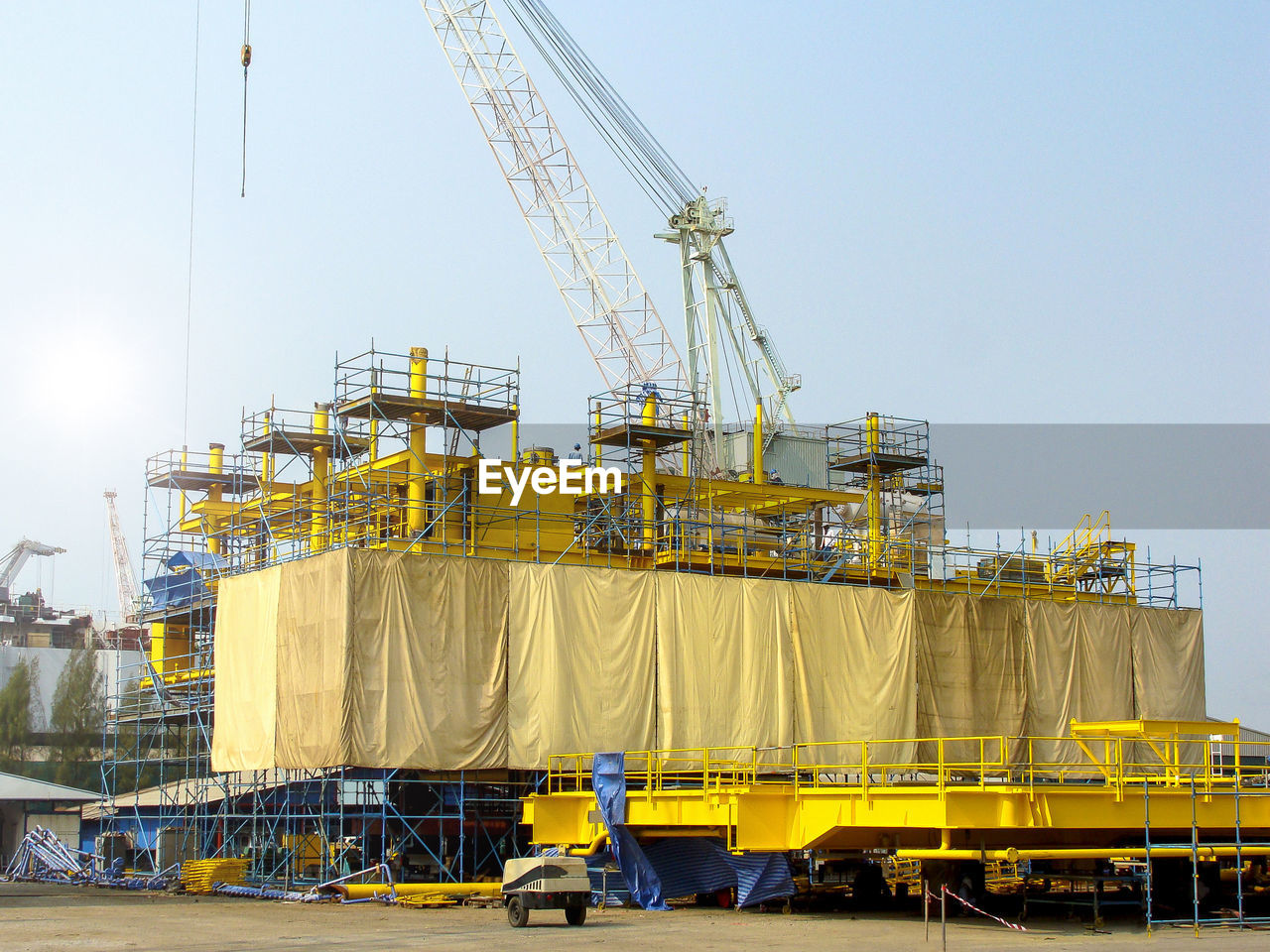 CRANE AT CONSTRUCTION SITE AGAINST SKY