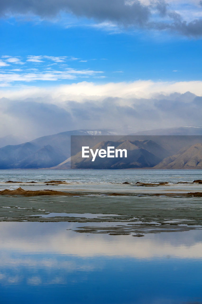 SCENIC VIEW OF LAKE BY MOUNTAIN AGAINST SKY