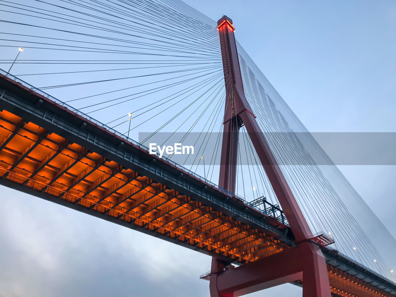 LOW ANGLE VIEW OF SUSPENSION BRIDGE AGAINST SKY IN CITY