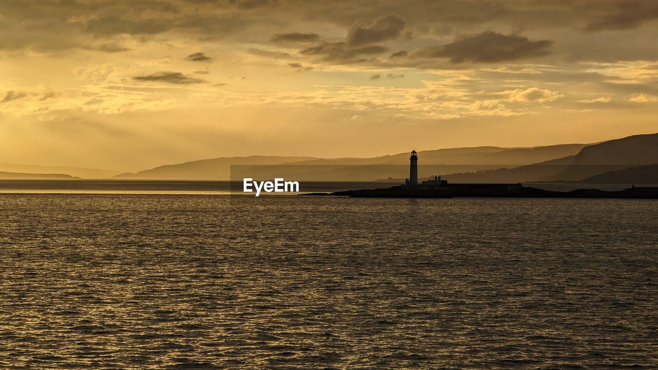 scenic view of sea against cloudy sky during sunset