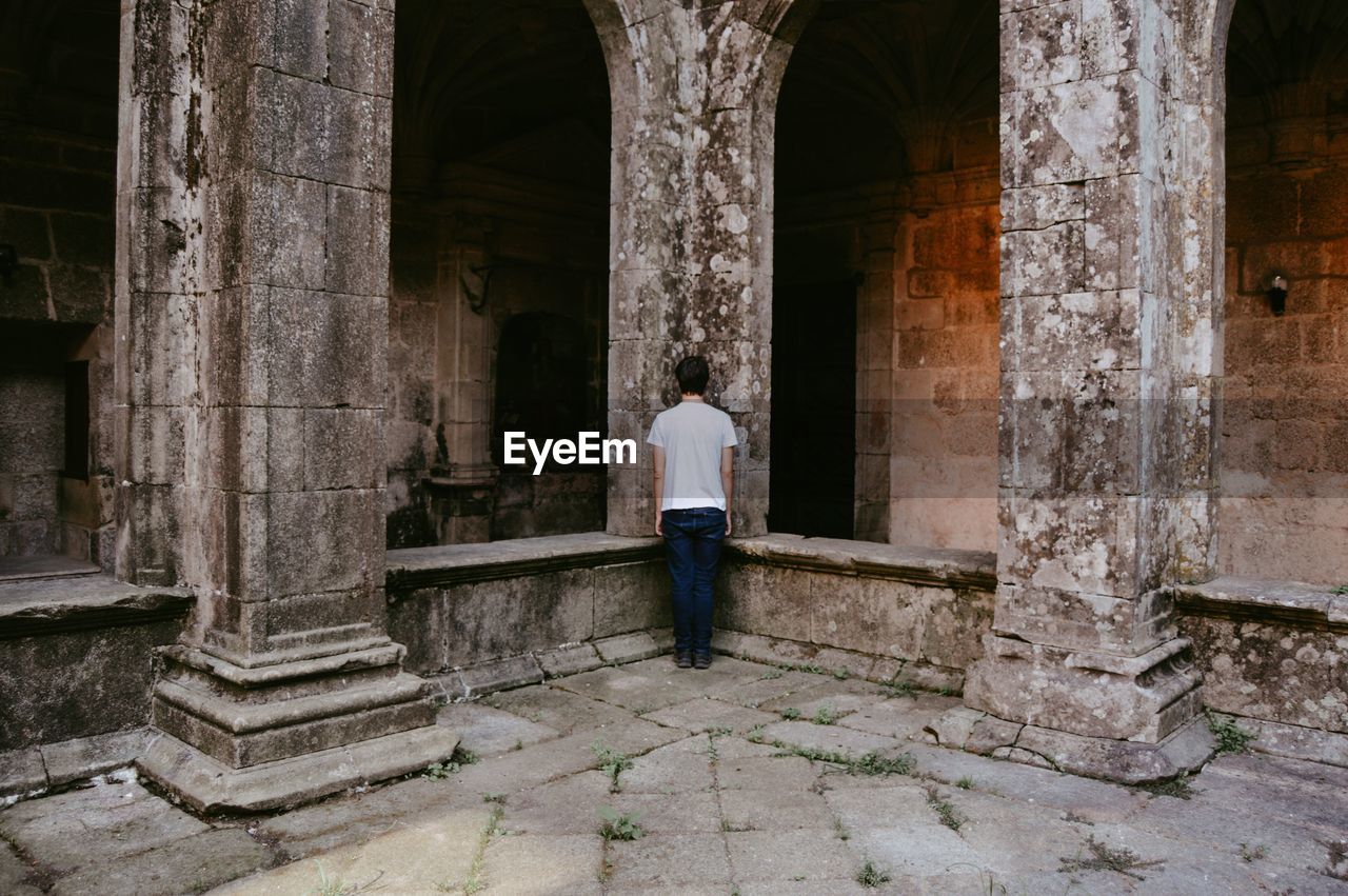 Rear view of man standing in front of historical building