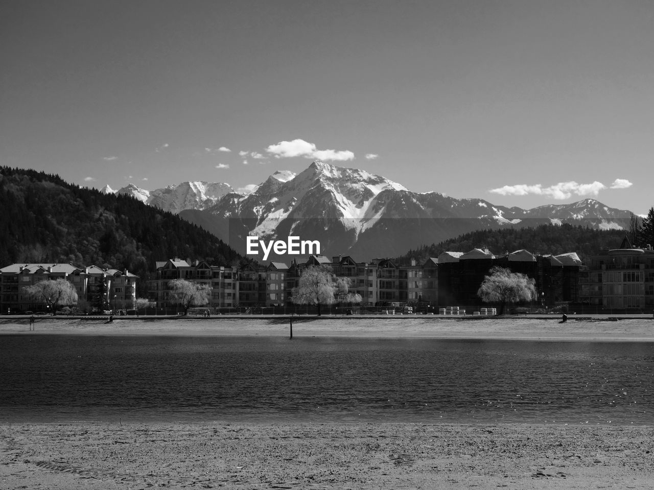 Scenic view of lake in front of snow capped mountains