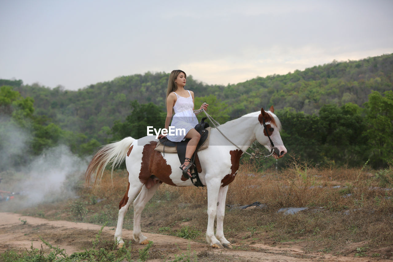 REAR VIEW OF WOMAN RIDING