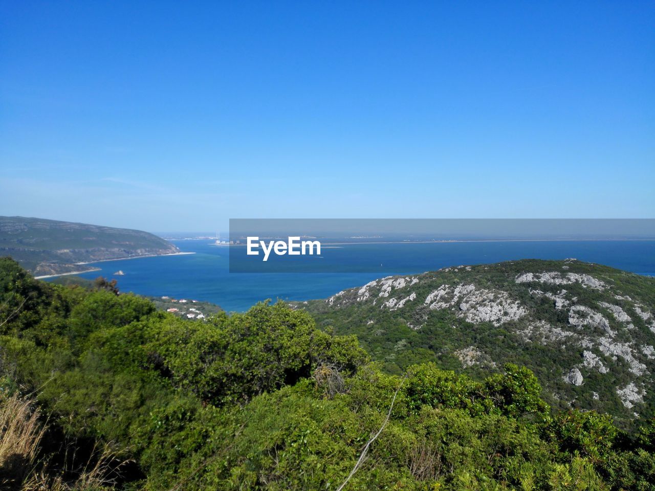 Scenic view of beach against clear blue sky