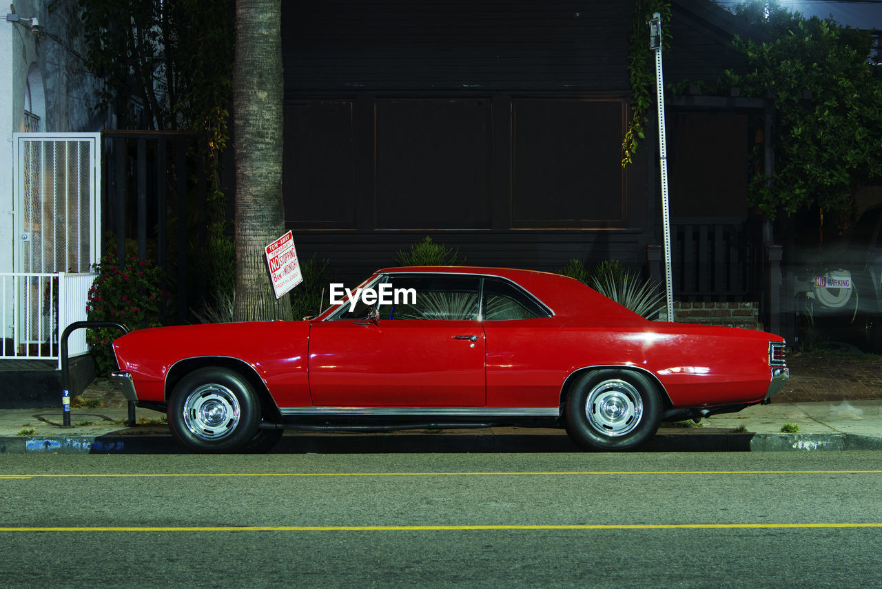 Side view of a classic vintage american muscle car in the street at night in venice, california