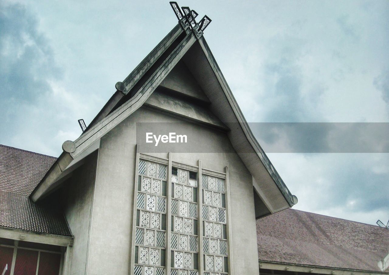 LOW ANGLE VIEW OF BUILDING AGAINST CLOUDS