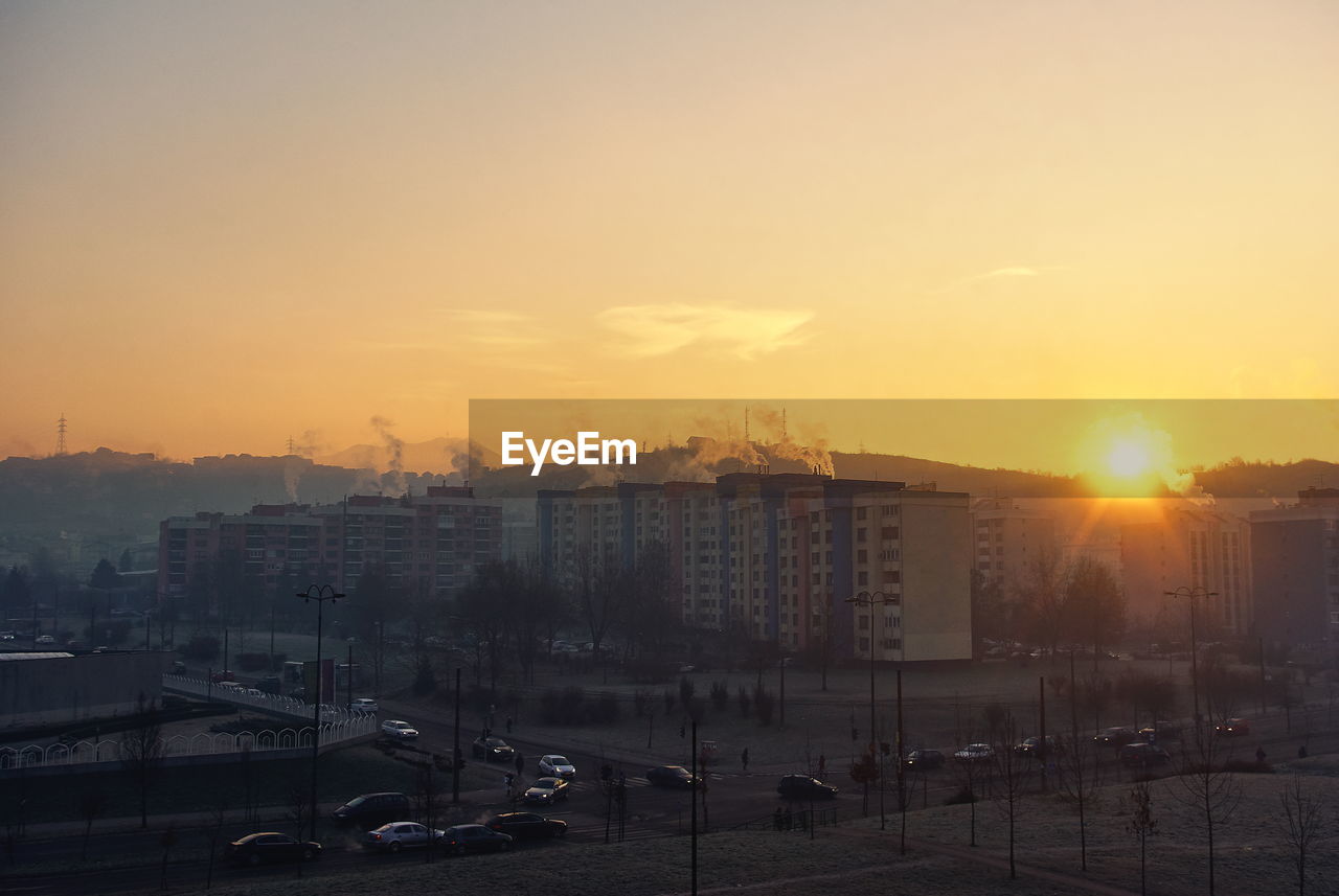 HIGH ANGLE VIEW OF BUILDINGS AGAINST SKY DURING SUNSET