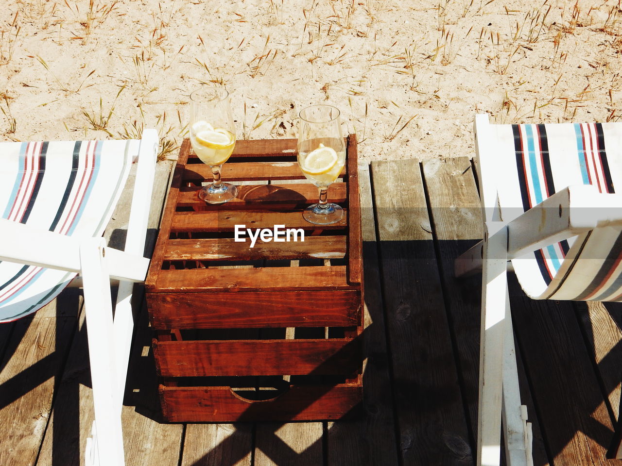 High angle view of deck chairs with drinks on table at beach