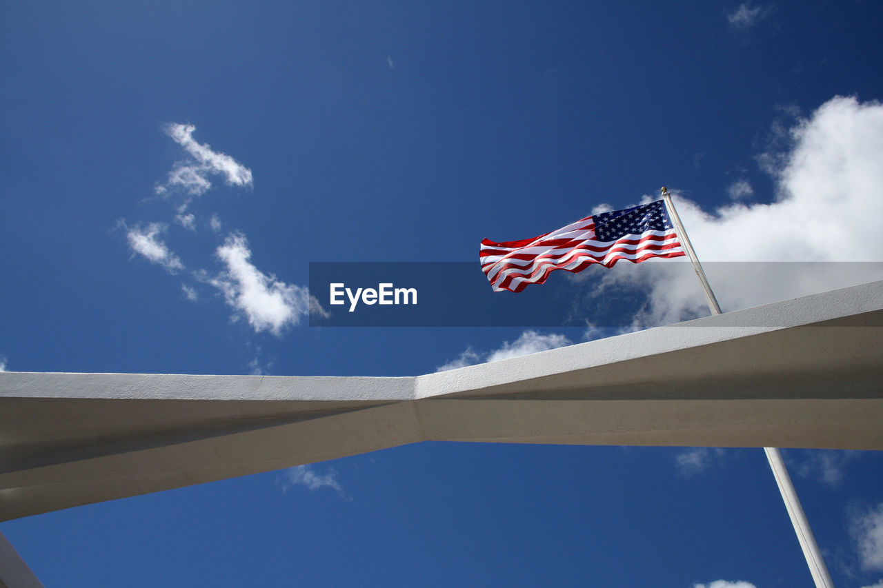 Low angle view of flag against blue sky