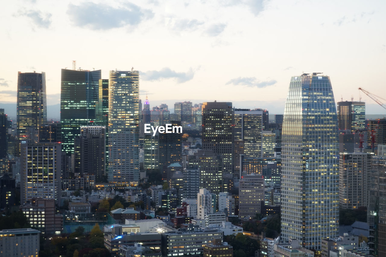 HIGH ANGLE VIEW OF MODERN BUILDINGS AGAINST SKY IN CITY