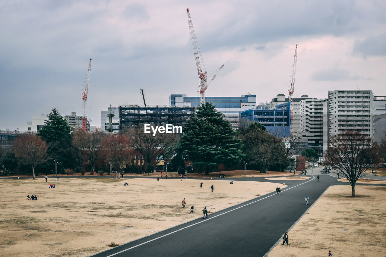 Construction site by buildings in city against sky