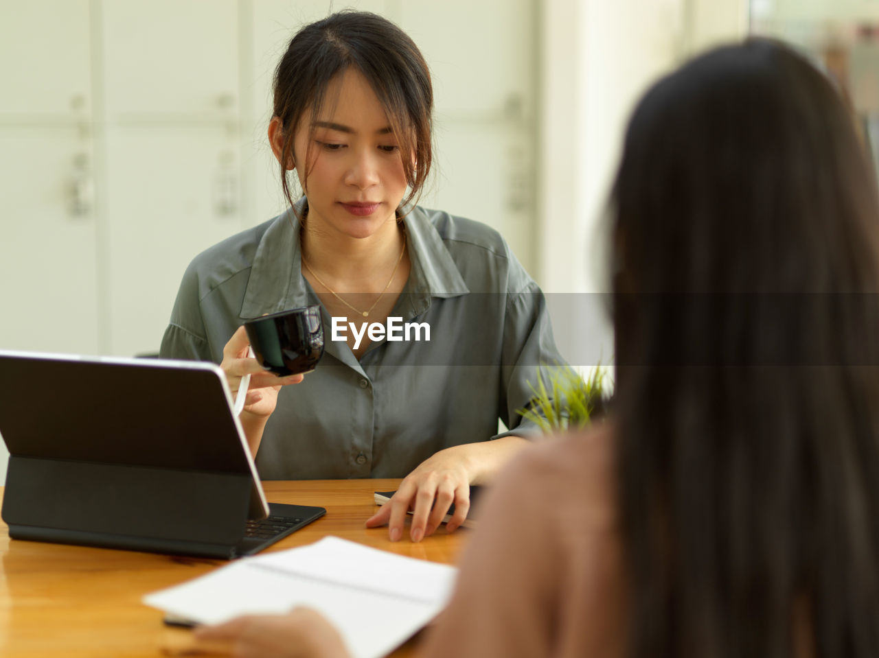 Businesswoman having coffee while working at office