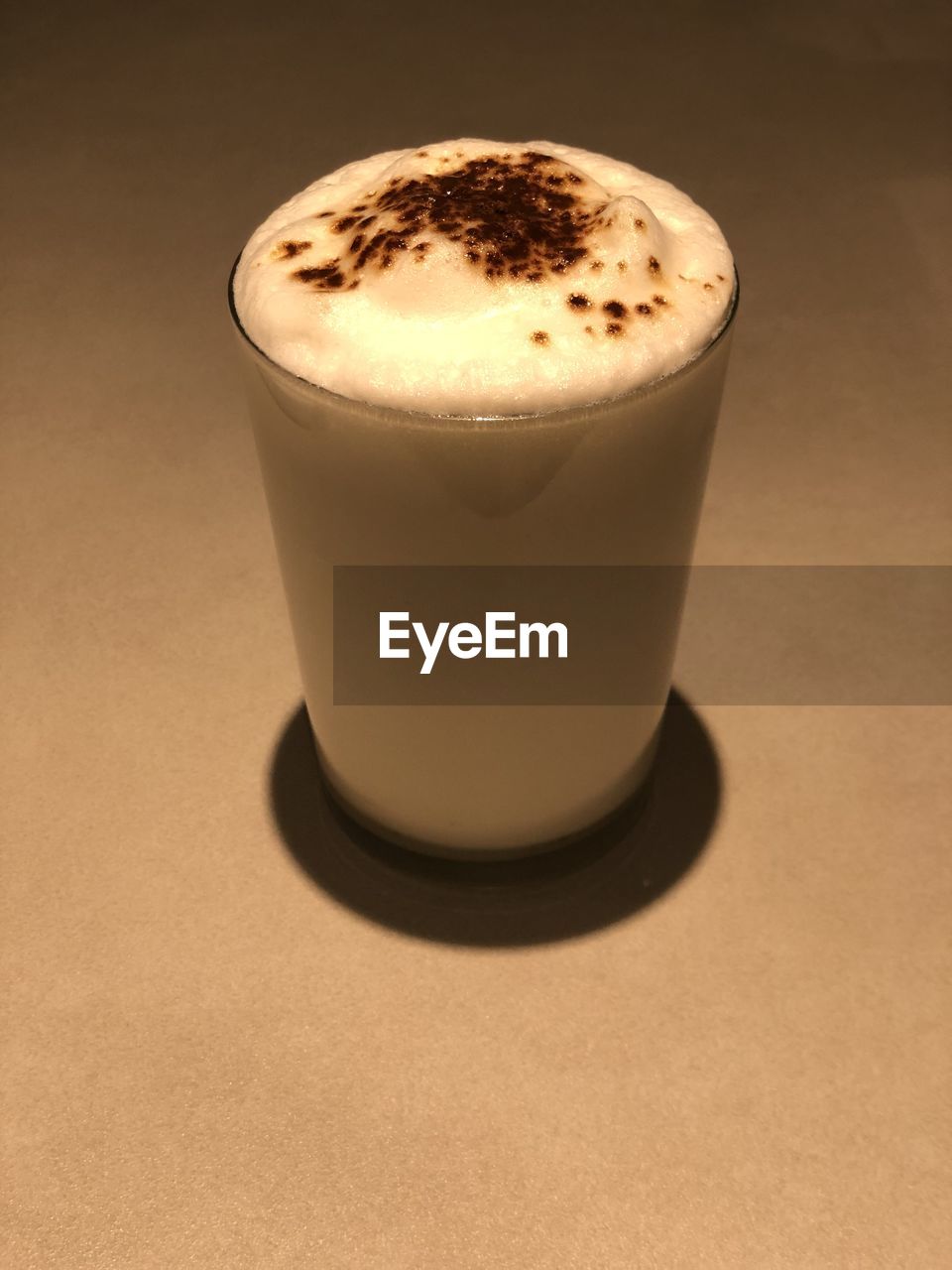 CLOSE-UP OF COFFEE CUP ON TABLE AGAINST BACKGROUND