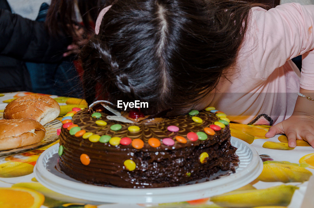 Birthday girl face on cake at table at party