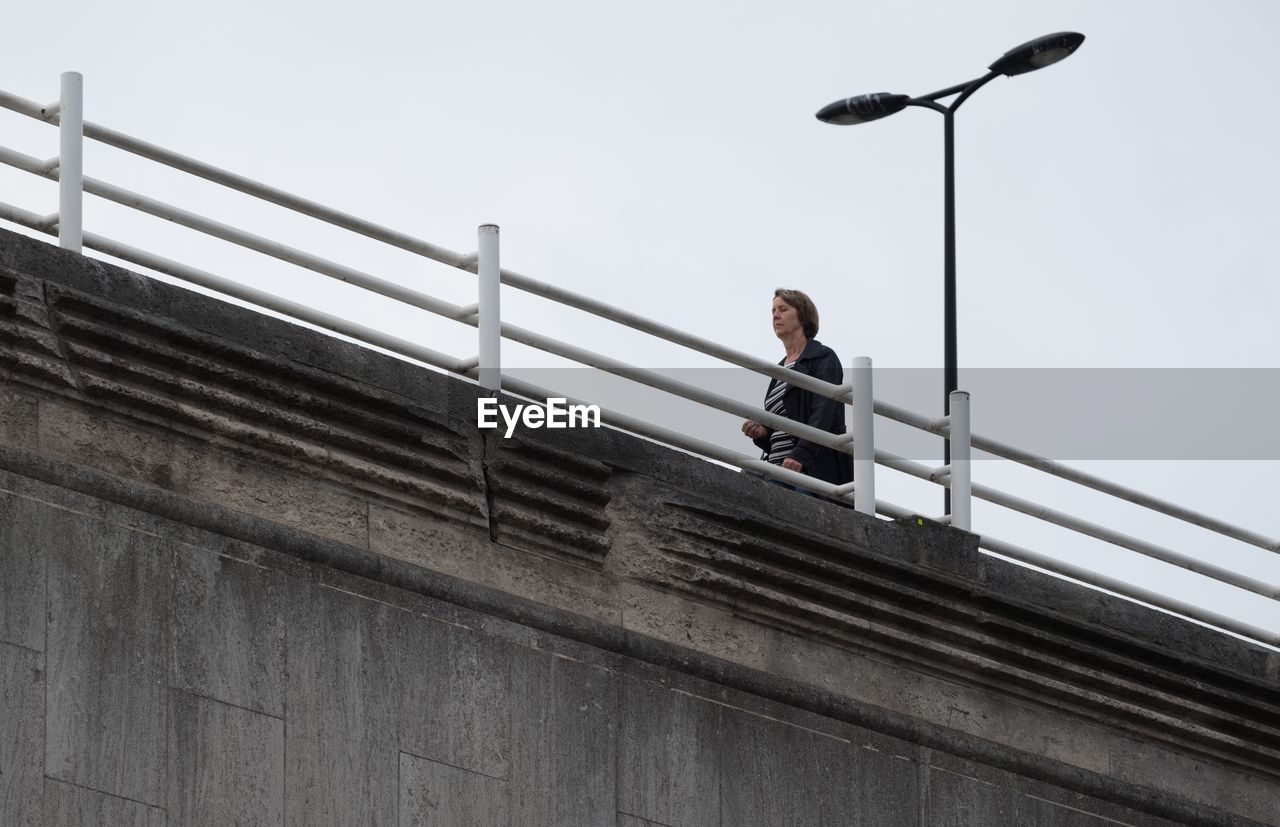 LOW ANGLE VIEW OF YOUNG WOMAN ON STEPS