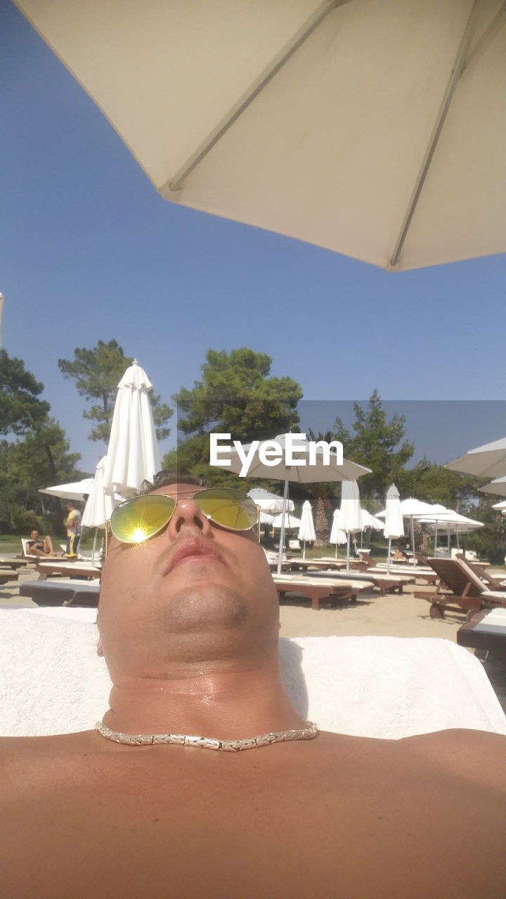 Man relaxing on lounge chair at beach