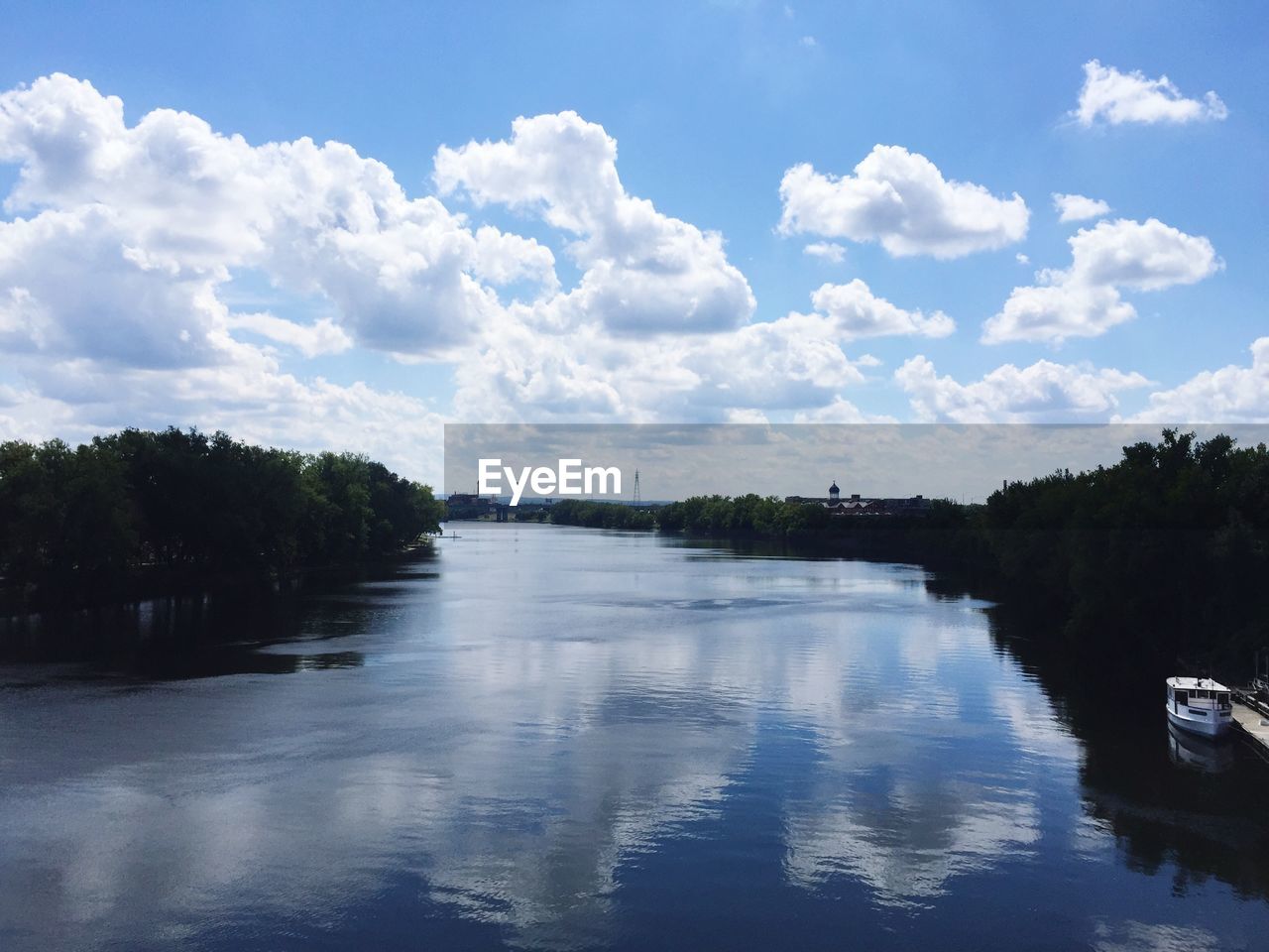 Scenic view of river amidst trees against cloudy sky
