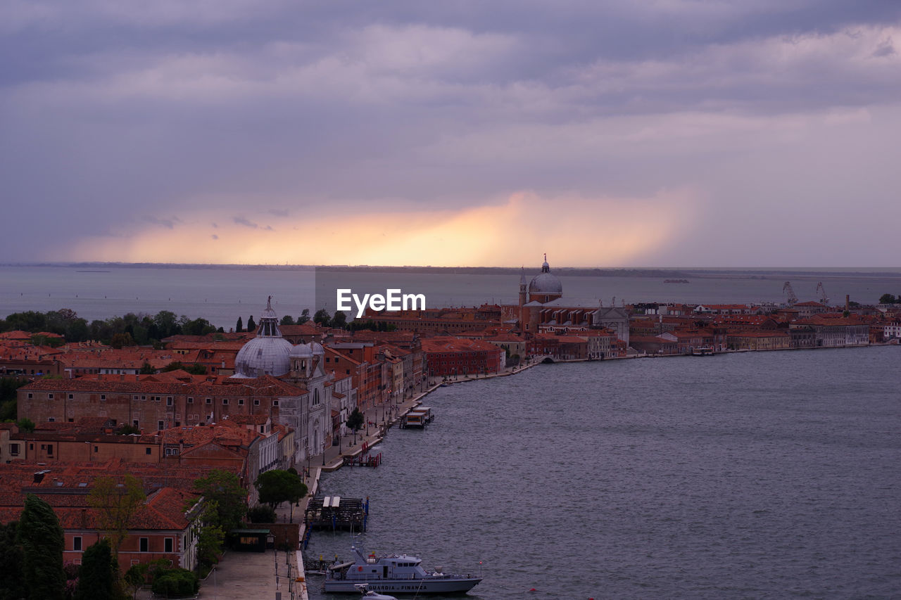 High angle view of buildings by sea against sky