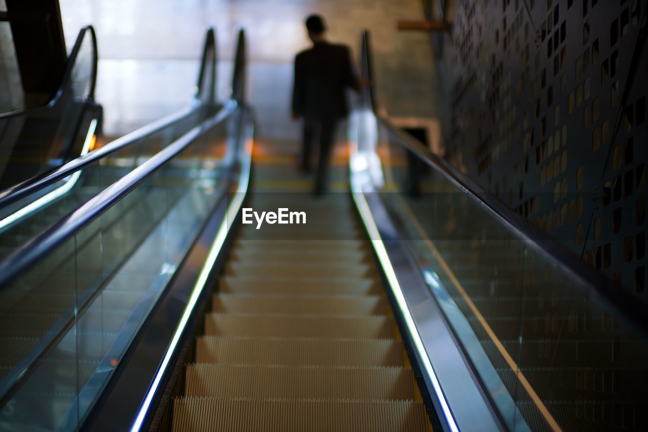 Blurred image of modern escalators staircase at shopping mall with vanishing escalators.
