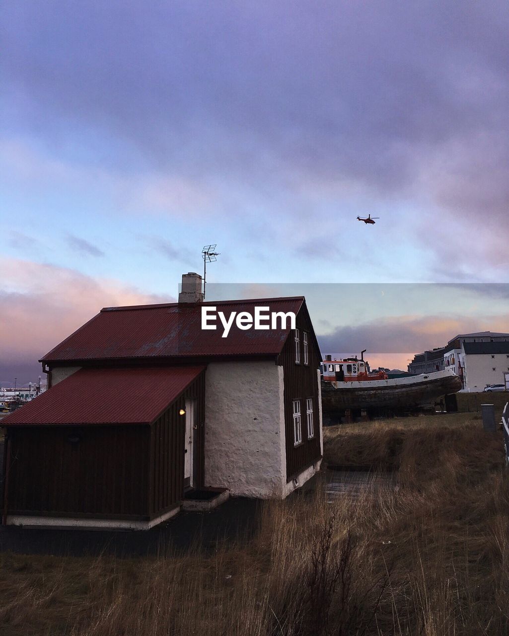 House against cloudy sky during sunset