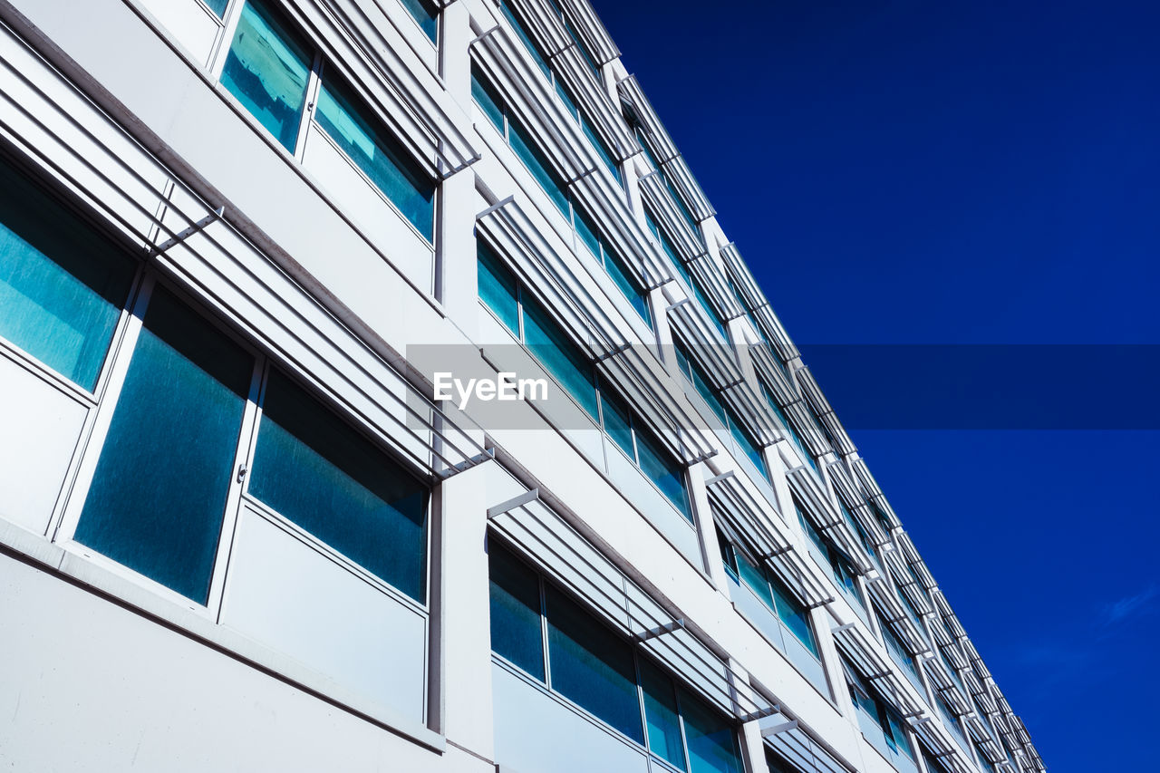 LOW ANGLE VIEW OF MODERN BUILDINGS AGAINST BLUE SKY