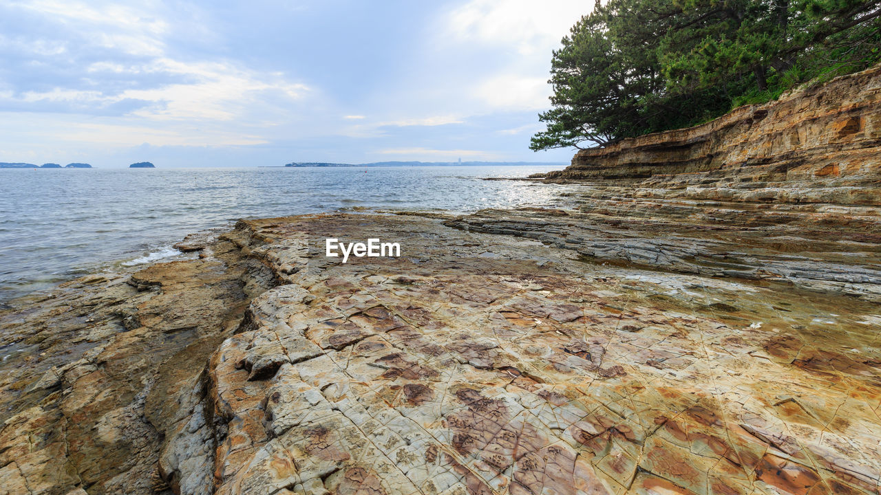 ROCKS ON BEACH AGAINST SKY