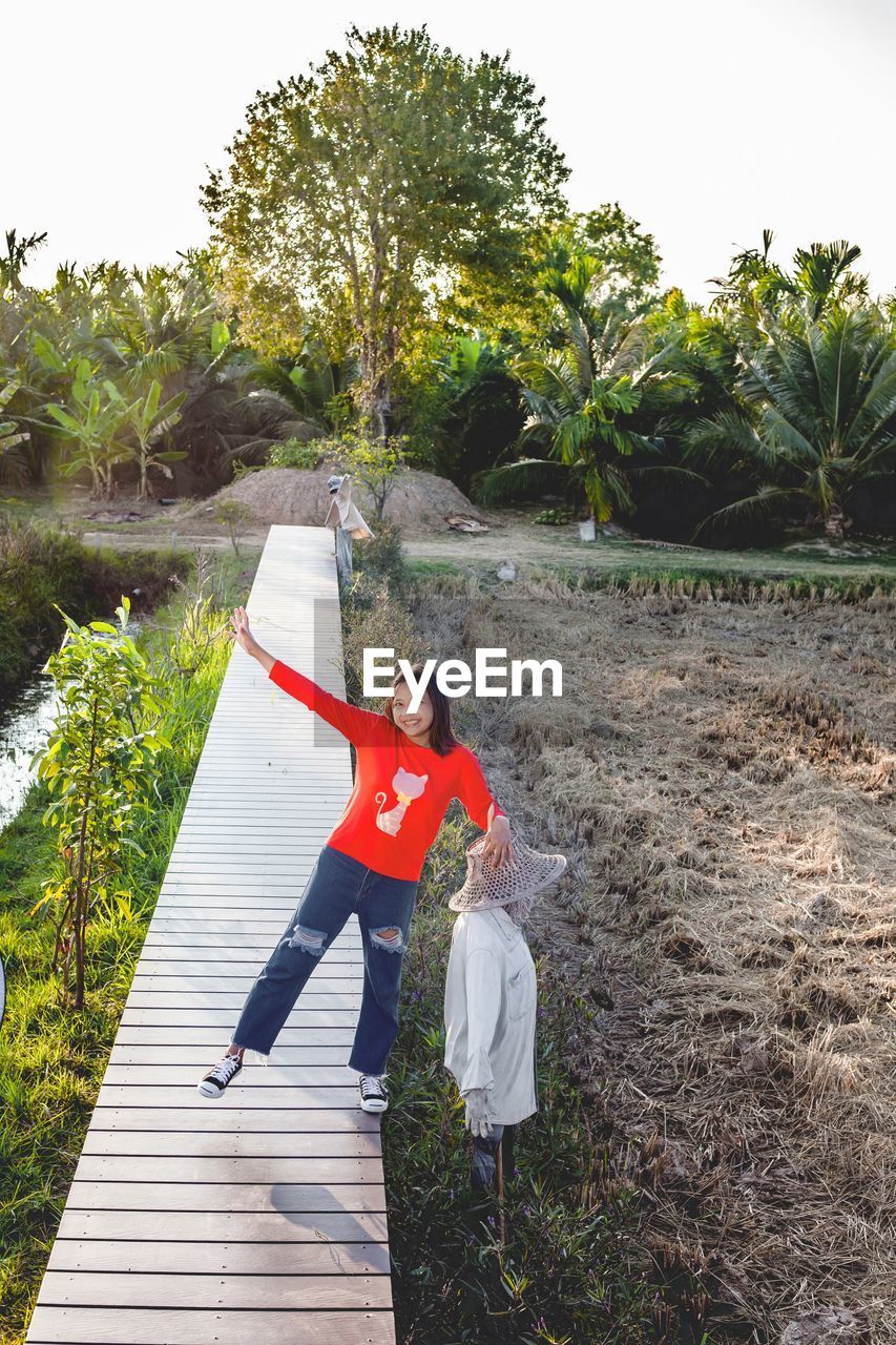 Full length of girl standing on boardwalk at farm