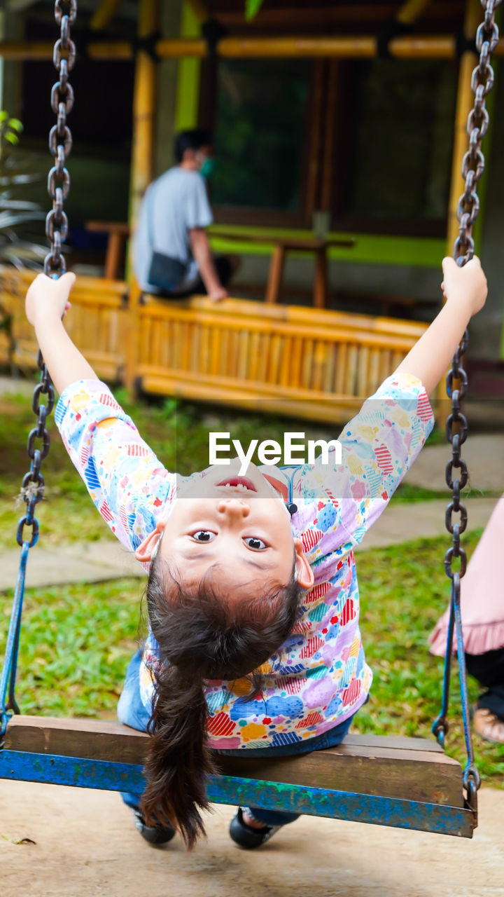 Close-up of girl on swing at playground