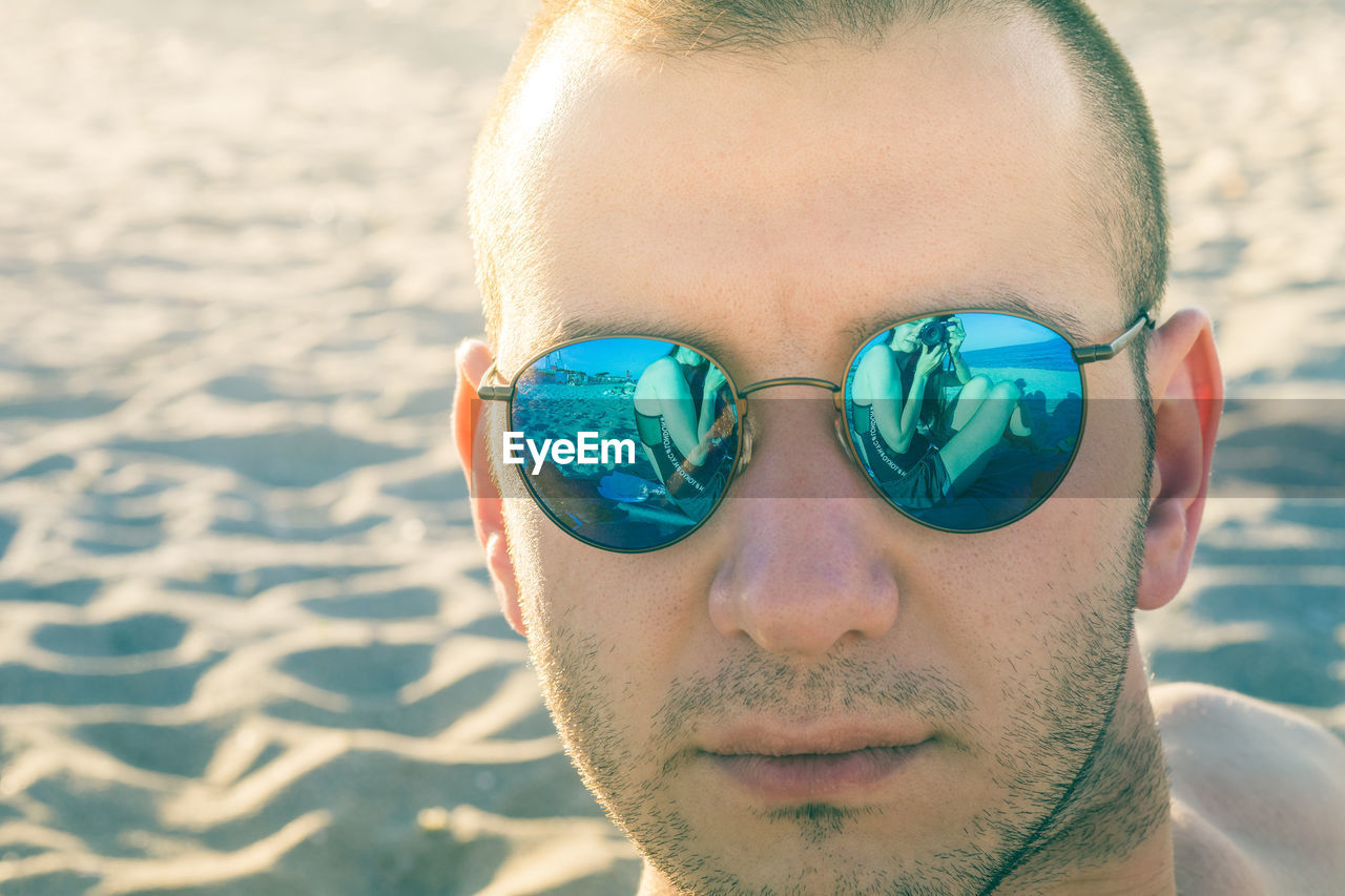Close-up portrait of man wearing sunglasses at beach during sunny day