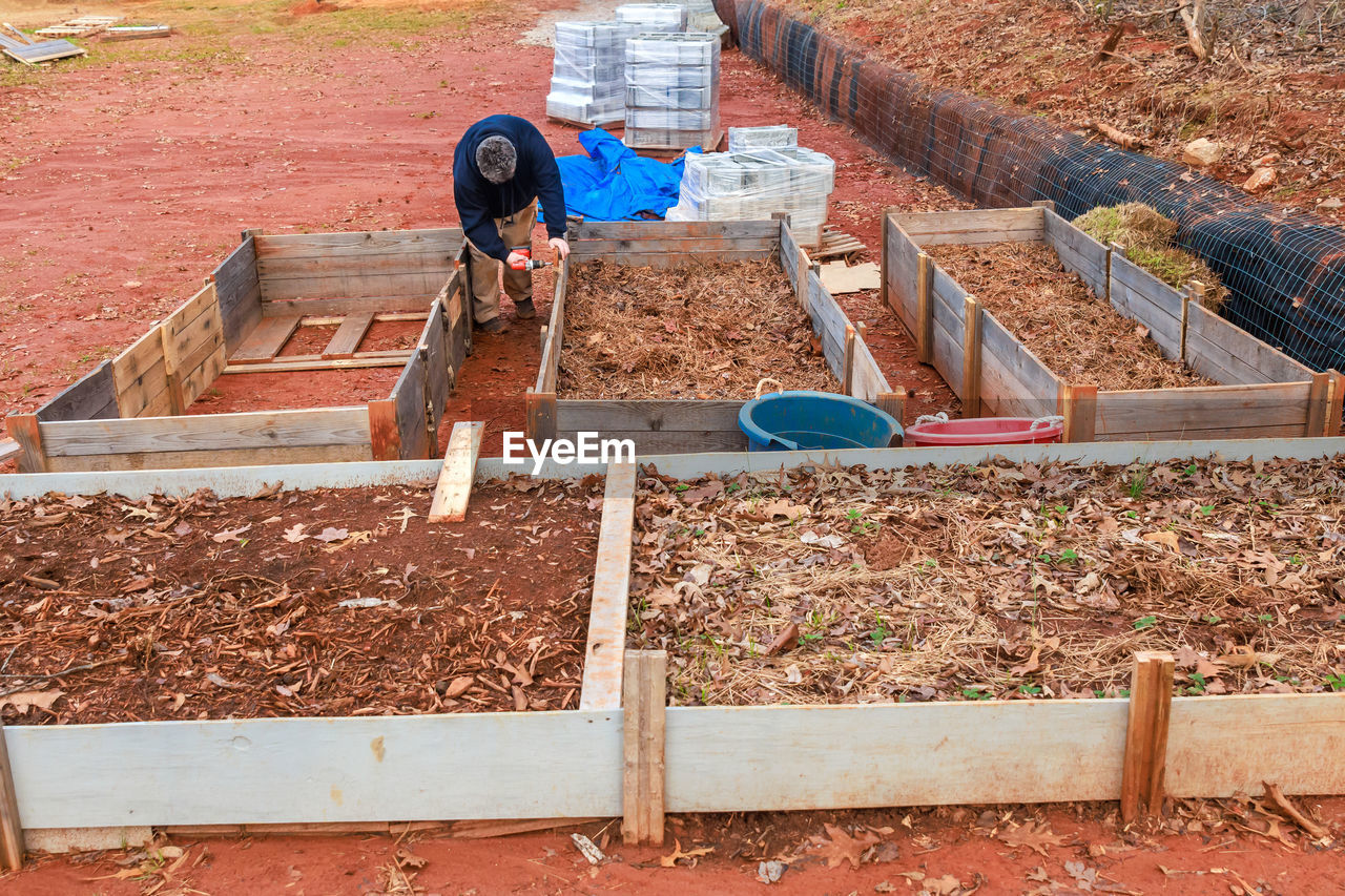 soil, construction, working, foundation, occupation, day, brickwork, nature, high angle view, backyard, mulch, agriculture, wall, outdoors, land, wood, men, construction industry, one person, yard, rural scene, plant